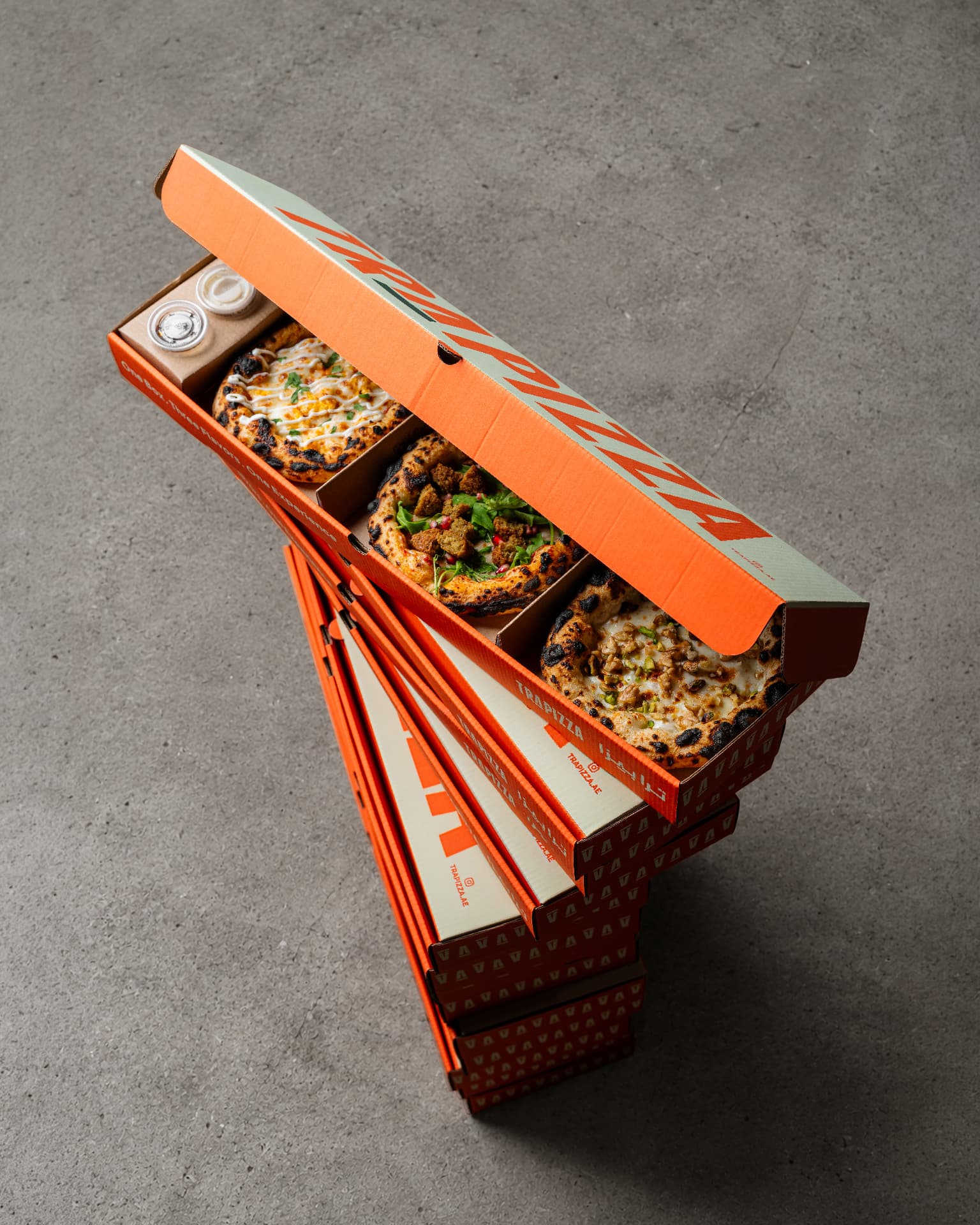 Open Trapizza box with three freshly baked pizzas